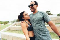 Young man and woman wearing sports clothing, outdoors, hugging, South Point Park, Miami Beach, Florida, USA — Stock Photo
