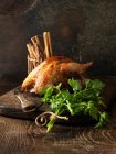 Pollo asado y perejil sobre tabla de madera - foto de stock