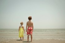 Дети, стоящие на пляже вместе — стоковое фото