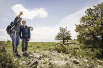 Caminhadas pai e filho adolescente com mapa apontando sobre a paisagem, Cody, Wyoming, EUA — Fotografia de Stock