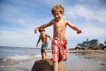 Dos chicos jugando en la playa - foto de stock