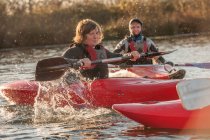 Femmes adultes milieu kayak sur le lac — Photo de stock