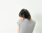 Vista posteriore della donna con mano sulla spalla isolata sul dorso bianco — Foto stock