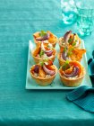 Plate of baked vegetable tarts served on table — Stock Photo