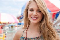 Adolescente sonriendo en el parque de atracciones - foto de stock
