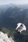 Männlicher Basejumper Wingsuit fliegt von den Bergen, Dolomiten, Italien — Stockfoto