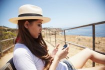Mujer joven usando teléfono celular, Palos Verdes, California, EE.UU. - foto de stock