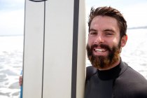Nahaufnahme Porträt eines jungen männlichen Surfers mit Surfbrett — Stockfoto