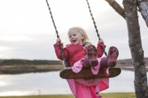 Девушка качается на качелях на детской площадке, Рейкьявик, Исландия — стоковое фото