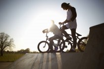Dos jóvenes en bicicletas bmx en skatepark - foto de stock