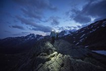 Pareja joven caminando por la noche con faros, Glaciar Val Senales, Val Senales, Tirol del Sur, Italia - foto de stock