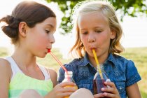 Rindo meninas beber suco ao ar livre — Fotografia de Stock
