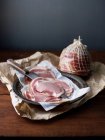 Netted pancetta with slices and knife — Stock Photo