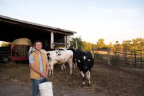 Portrait of farmer on farm, holding animal feed — Stock Photo