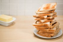Pila di pane tostato con burro sullo sfondo — Foto stock