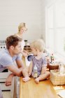 Jovens pais com criança na cozinha — Fotografia de Stock