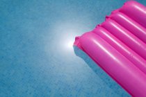 Colchão inflável rosa na piscina — Fotografia de Stock
