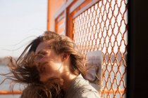 Giovane donna su un traghetto, vento che soffia capelli — Foto stock