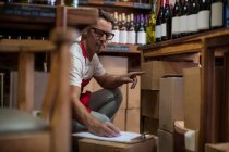 Cape Town, South Africa, young male wine shopkeeper counting stock — Stock Photo