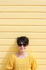 Jovem mulher e parede amarela — Fotografia de Stock