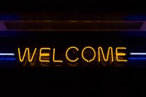 Welcome neon sign in dark background — Stock Photo