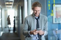 Бізнесмен використовує мобільний телефон в офісі — стокове фото