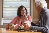 Senior couple chatting at kitchen table — Stock Photo