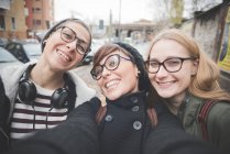 Three sisters taking selfie on street — Stock Photo