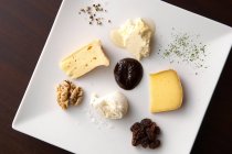 Käse mit Nüssen und Soße auf Teller — Stockfoto