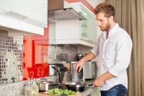 Mann kocht in Küche, Fokus auf Vordergrund — Stockfoto