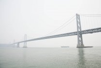 Distant view of Bay bridge in foggy weather, San Francisco, USA — Stock Photo