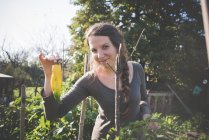 Mujer joven sosteniendo pimienta amarilla de cosecha propia - foto de stock