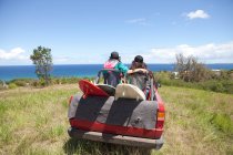 Off road vehicle driving toward beach with two women in back — Stock Photo