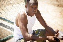 Ritratto di giovane giocatore di basket maschile con smartphone e acqua potabile — Foto stock