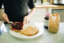 Abgeschnittenes Bild eines Jungen, der Sandwich macht — Stockfoto