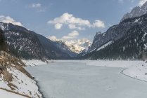 Lago congelado e montanhas cobertas de neve sob céu azul — Fotografia de Stock