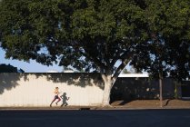 Junge Frau turnt im Freien und rennt entlang der Straße — Stockfoto