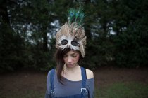 Young woman with feathered mask on her head — Stock Photo