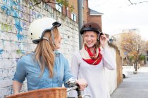 Mulheres em bicicletas na rua da cidade — Fotografia de Stock