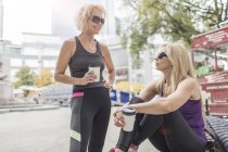 Zwei reife Freundinnen beim Training in der Stadt, plaudern mit Kaffee zum Mitnehmen — Stockfoto