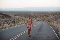 Short homme et boxeur debout sur la route rurale, Valley of Fire State Park, Nevada, États-Unis — Photo de stock