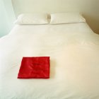 Червона піжама складена на білому ліжку — стокове фото
