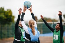 Женские нетбольные команды бросают мяч на площадку — стоковое фото