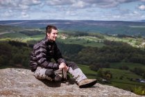 Young male hiker opening flask on top of Guise Cliff, Pateley Bridge, Nidderdale, Yorkshire Dales — Stock Photo