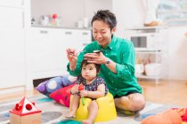 Father cutting baby's hair on floor — Stock Photo