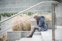 Uomo d'affari seduto su scale sms su smartphone — Foto stock