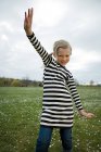 Girl with arms raised in the meadow — Stock Photo
