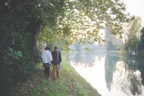 Jeune couple marchant au bord de la rivière, Dolo, Venise, Italie — Photo de stock
