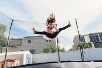 Дівчина в повітрі стрибає на батуті — стокове фото