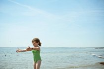 Mädchen spielt mit Sand am Strand — Stockfoto